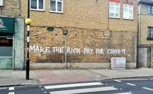 σύνθημα σε τοίχο: να πληρώσουν οι πλούσιοι για τον Covid-19
